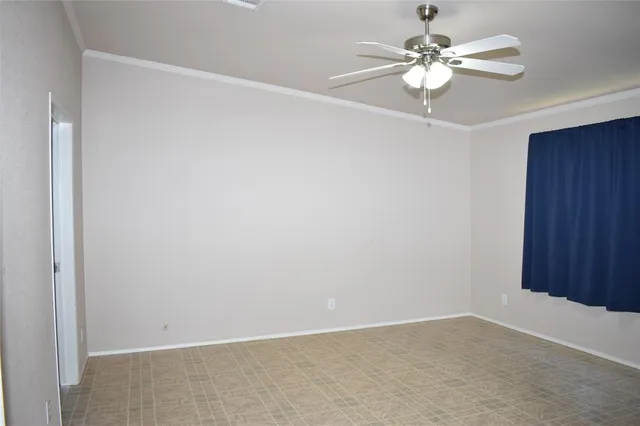 an empty room with a chandelier fan