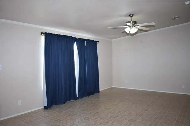 a view of an empty room with a chandelier fan