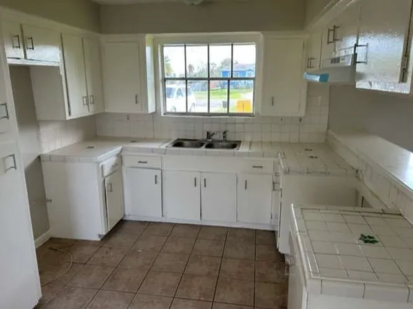 a kitchen with a sink a stove and cabinets