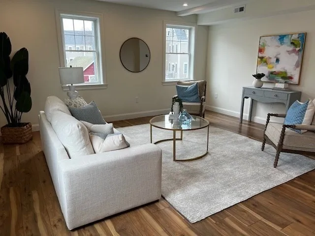 a living room with furniture a window and a potted plant