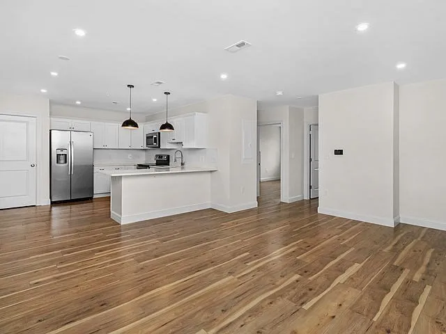 a view of a kitchen with a sink and a refrigerator