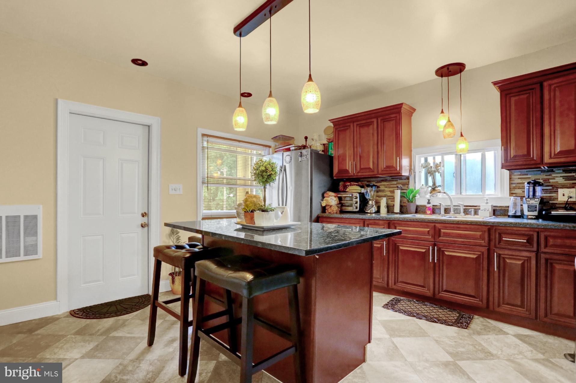 1742 Mineral Spring Road Reading, PA 19602 - Photo 11 of 31 a kitchen with stainless steel appliances granite countertop wooden cabinets a dining table and chairs