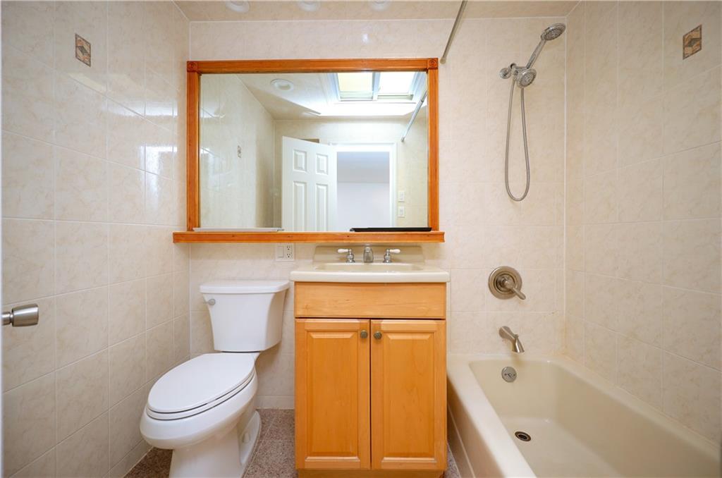 1940 20th Drive Brooklyn, NY 11214 - Photo 12 of 21 a bathroom with a granite countertop sink toilet and shower