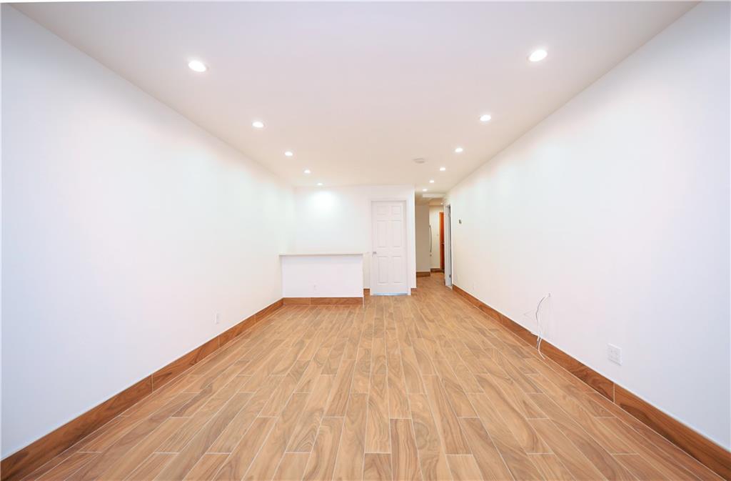 1940 20th Drive Brooklyn, NY 11214 - Photo 14 of 21 a view of an empty room with wooden floor and a window