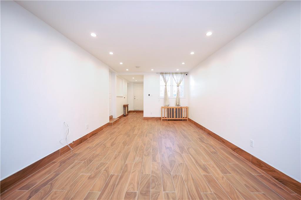 1940 20th Drive Brooklyn, NY 11214 - Photo 15 of 21 a view of empty room with wooden floor and fan