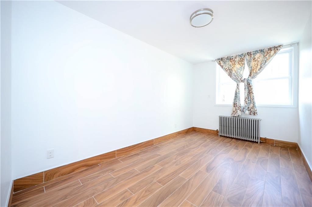 1940 20th Drive Brooklyn, NY 11214 - Photo 16 of 21 a view of empty room with wooden floor and fan