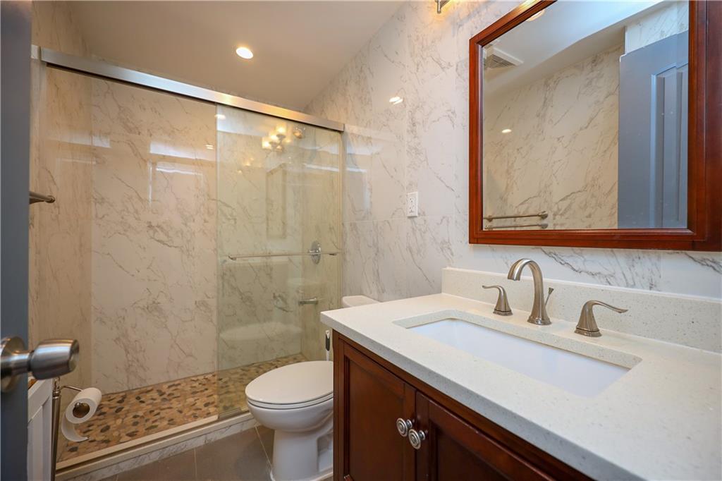1940 20th Drive Brooklyn, NY 11214 - Photo 18 of 21 a bathroom with a sink toilet and shower