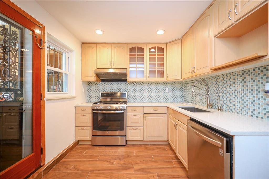 1940 20th Drive Brooklyn, NY 11214 - Photo 19 of 21 a kitchen with stainless steel appliances granite countertop a stove a sink and a microwave