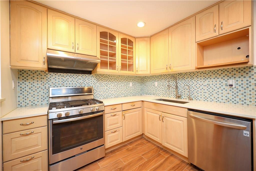 1940 20th Drive Brooklyn, NY 11214 - Photo 20 of 21 a kitchen with granite countertop cabinets stainless steel appliances and a sink
