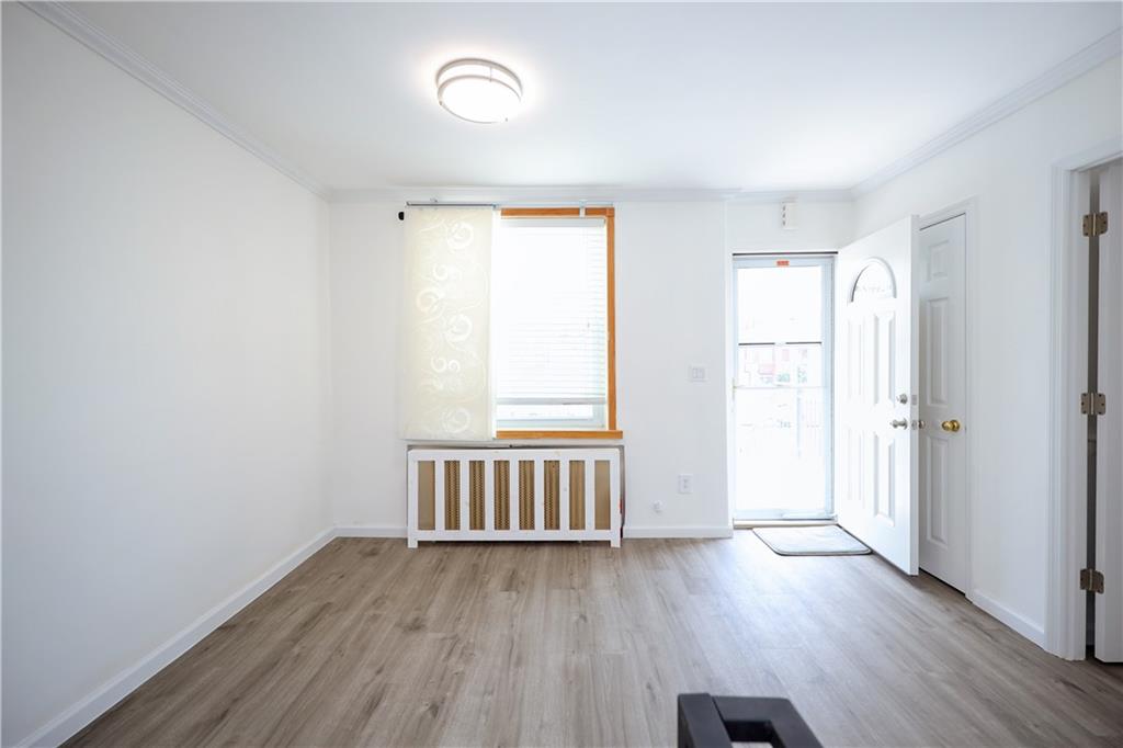 1940 20th Drive Brooklyn, NY 11214 - Photo 6 of 21 an empty room with wooden floor and windows