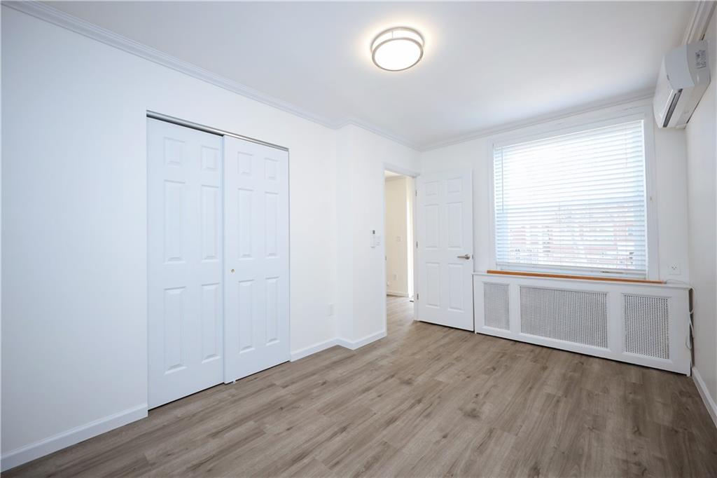 1940 20th Drive Brooklyn, NY 11214 - Photo 9 of 21 an empty room with wooden floor and windows