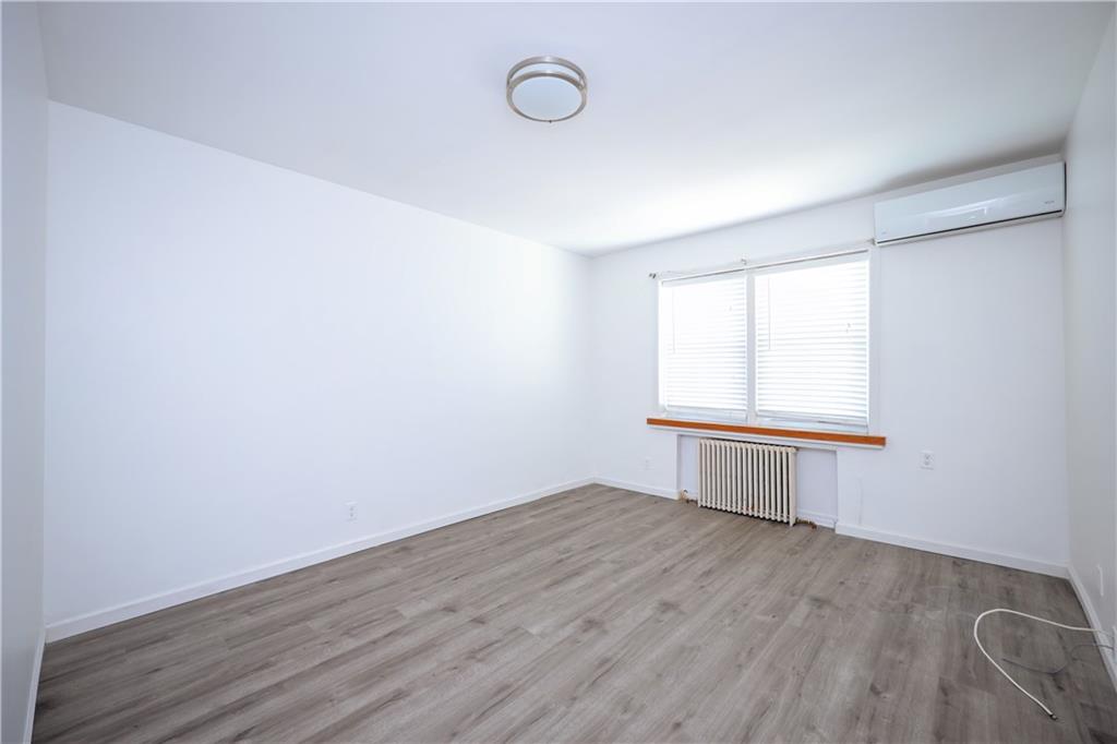 1940 20th Drive Brooklyn, NY 11214 - Photo 10 of 21 an empty room with wooden floor and windows