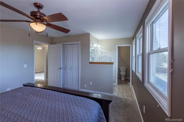 a bedroom with a bed and a chandelier fan