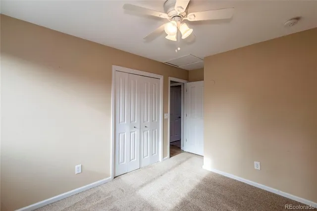 an empty room with a chandelier fan and a ceiling fan