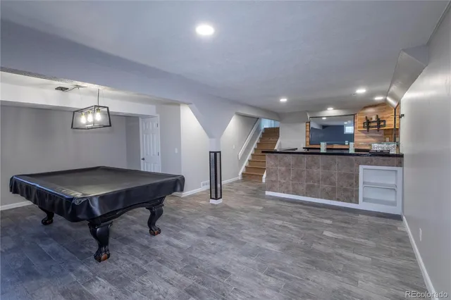 a living room with a table chairs and kitchen view
