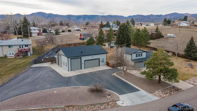an aerial view of a house with a garden and mountain view