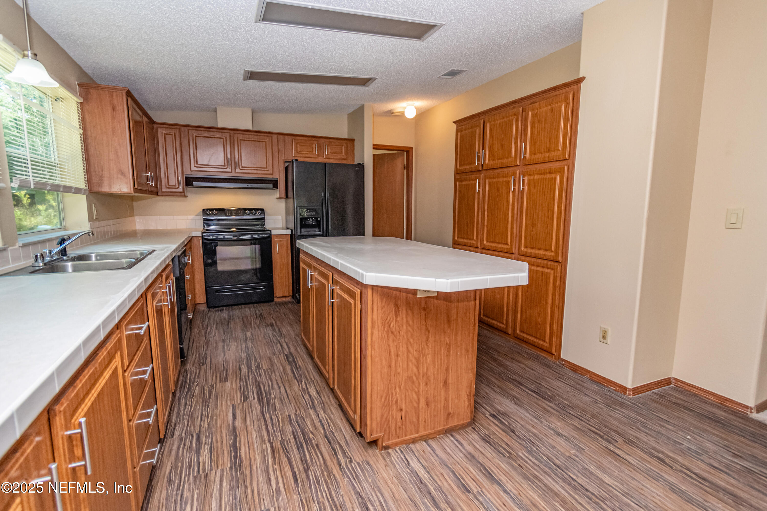 5577 Myrtle Road Macclenny, FL 32063 - Photo 16 of 58 a kitchen with stainless steel appliances granite countertop a stove top oven a refrigerator a sink and dishwasher with wooden floor