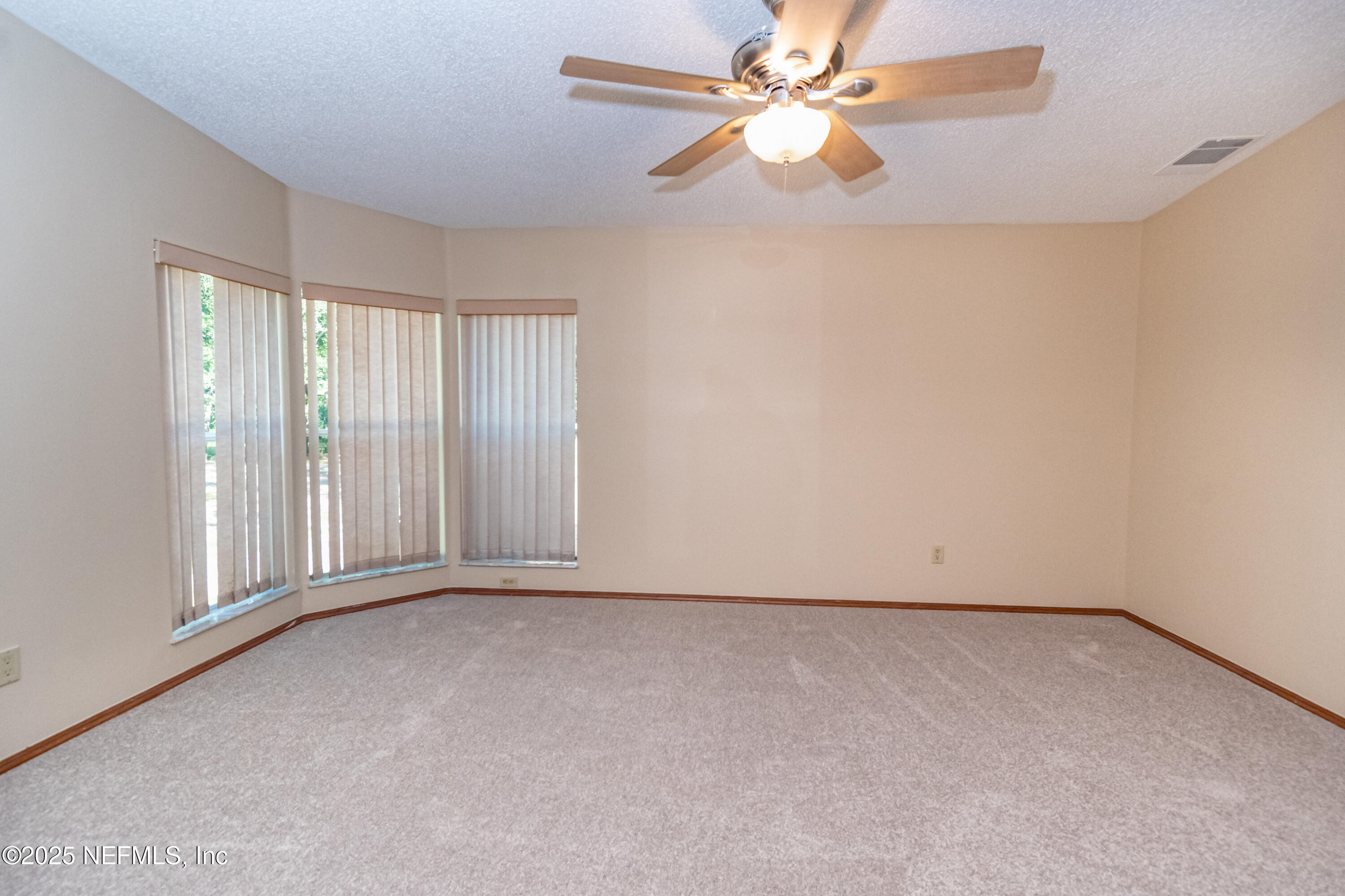 5577 Myrtle Road Macclenny, FL 32063 - Photo 21 of 58 an empty room with chandelier fan and windows
