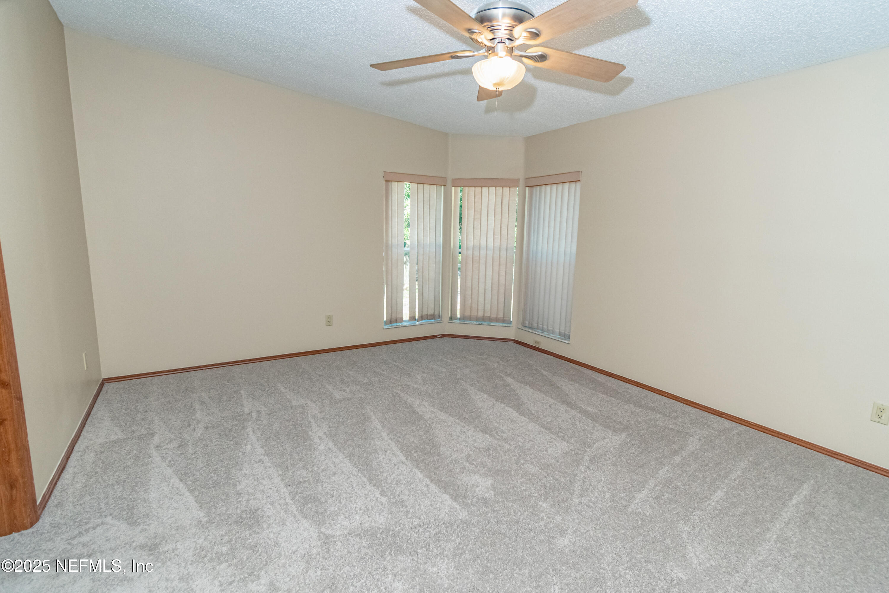5577 Myrtle Road Macclenny, FL 32063 - Photo 22 of 58 an empty room with a chandelier fan and windows