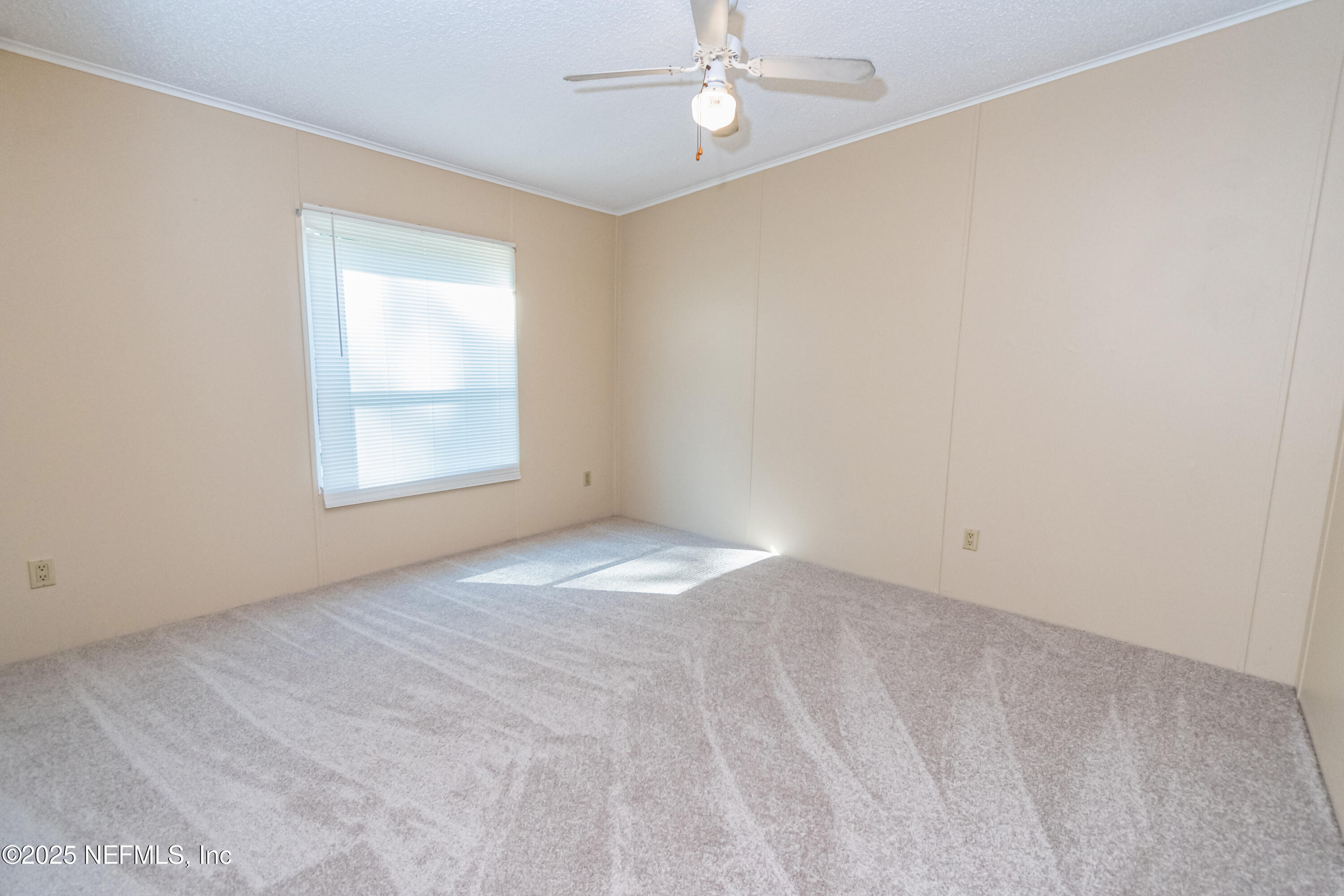 5577 Myrtle Road Macclenny, FL 32063 - Photo 27 of 58 an empty room with a chandelier fan and windows