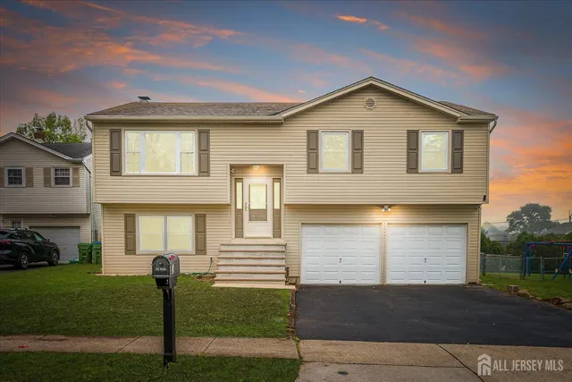 a front view of a house with a garden and yard