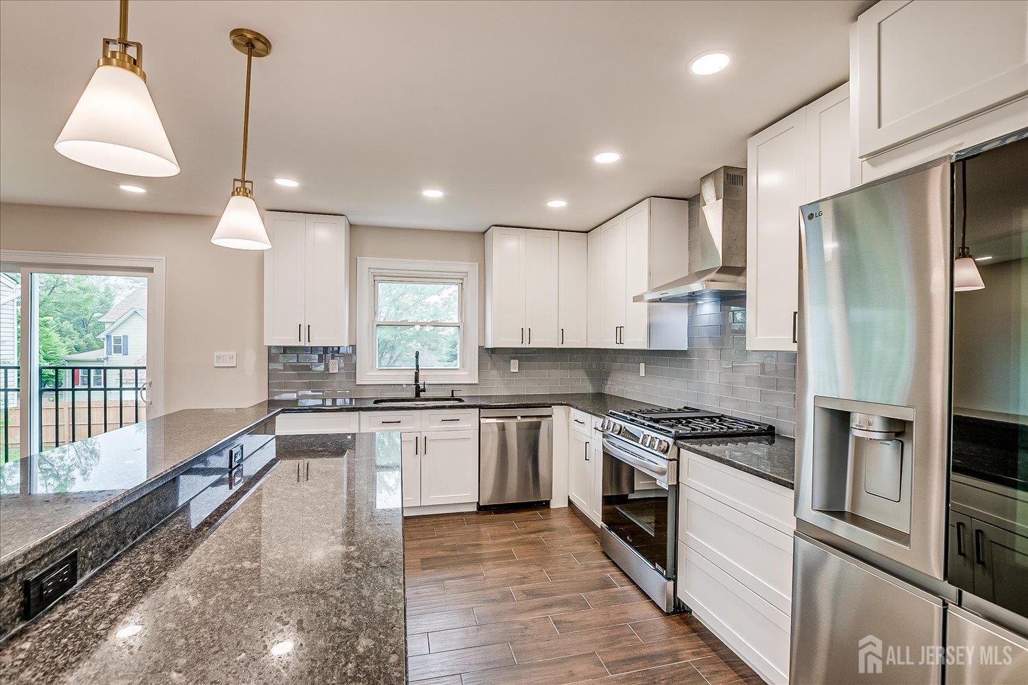 3 Birch Road Edison, NJ 08817 - Photo 13 of 33 a kitchen with stainless steel appliances granite countertop a sink a stove a refrigerator cabinets and a large window