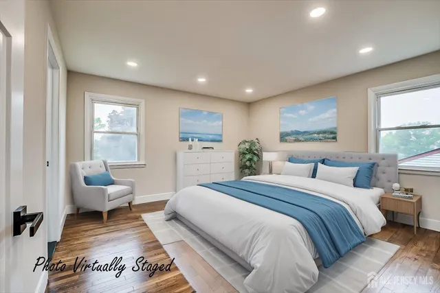 a spacious bedroom with a large bed a couch and two window