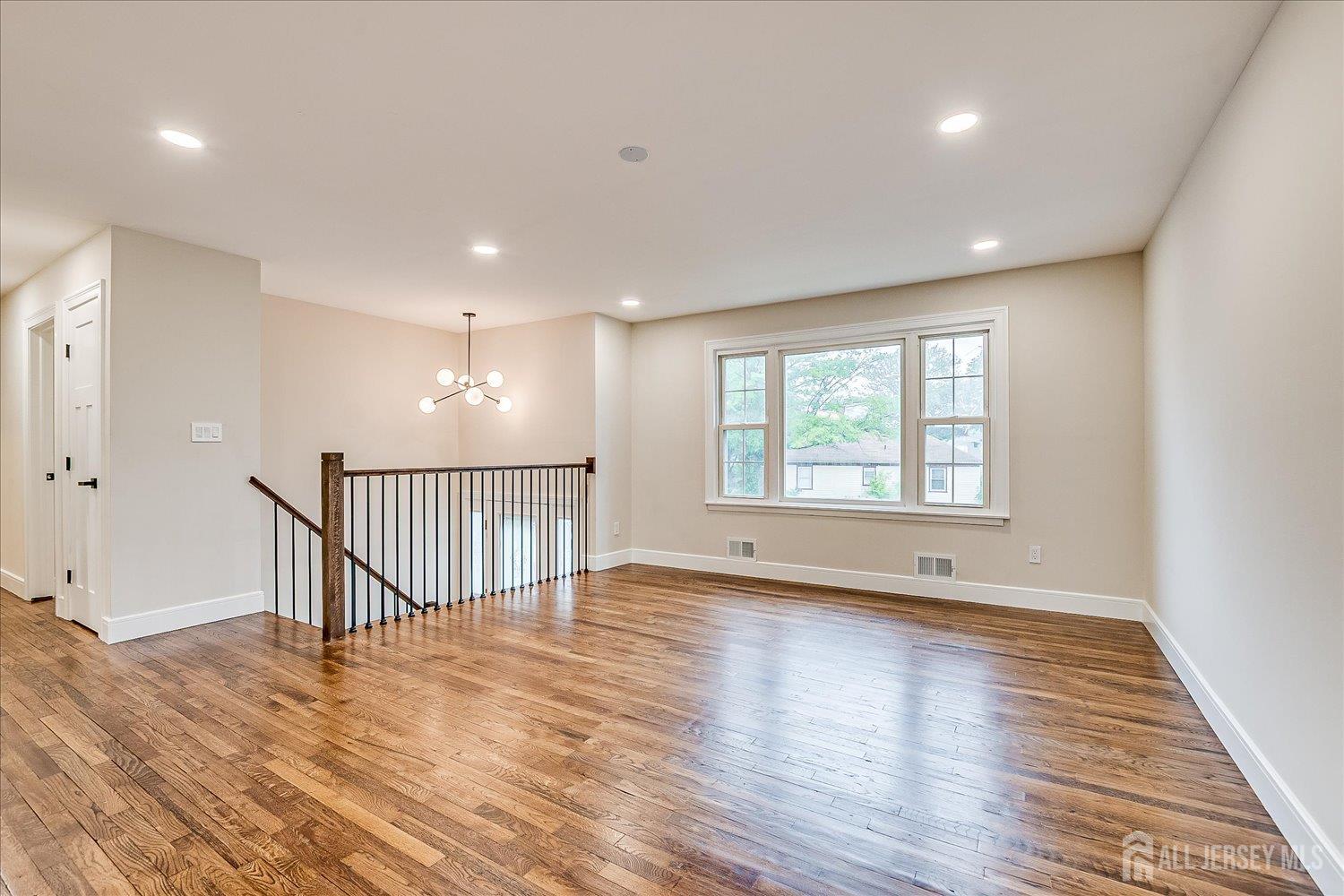 3 Birch Road Edison, NJ 08817 - Photo 6 of 33 a view of an empty room with wooden floor and a window