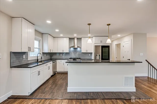 a large kitchen with stainless steel appliances granite countertop a stove and a sink