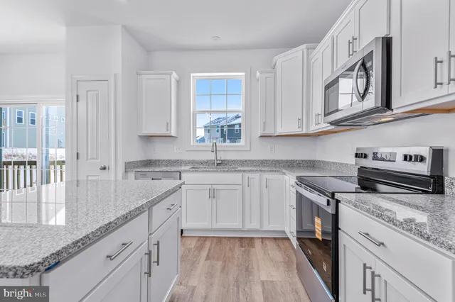 a kitchen with granite countertop white cabinets and white appliances