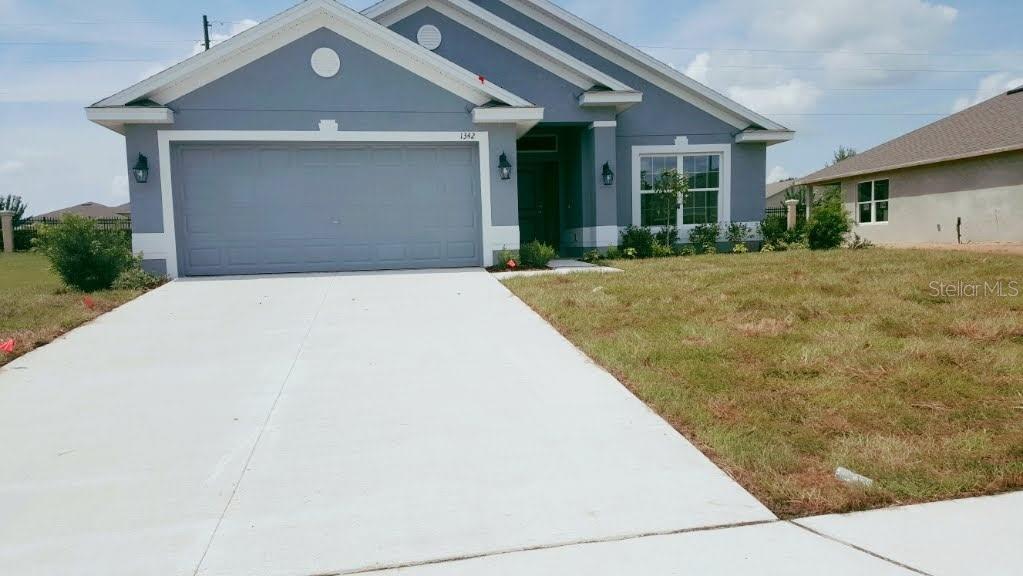 Undisclosed Address Dundee, FL 33838 - Photo 1 of 1 a front view of a house with a yard and garage