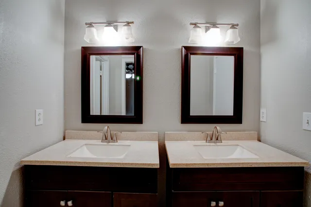 a bathroom with double vanity sinks and a mirror