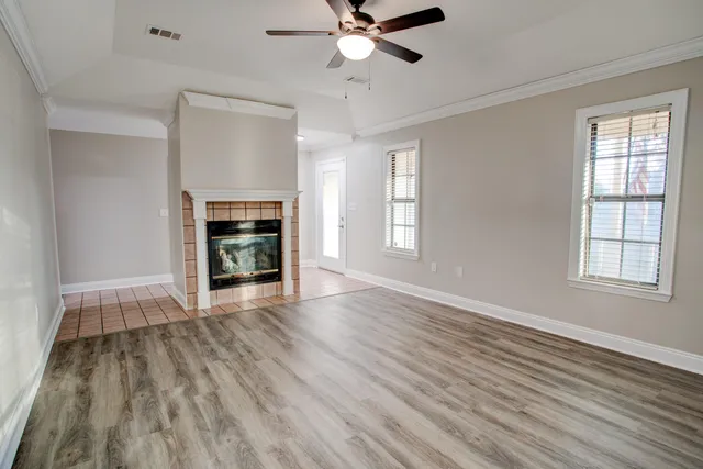 wooden floor fireplace and windows in an empty room