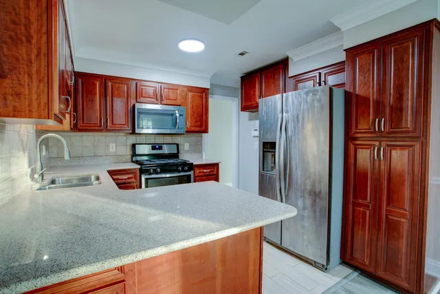 a kitchen with stainless steel appliances granite countertop a refrigerator and a sink