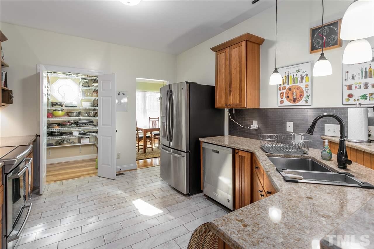 100 North Sunset Ridge Drive Willow Spring, NC 27592 - Photo 7 of 25 a kitchen with stainless steel appliances granite countertop a refrigerator a stove and a sink with wooden floors