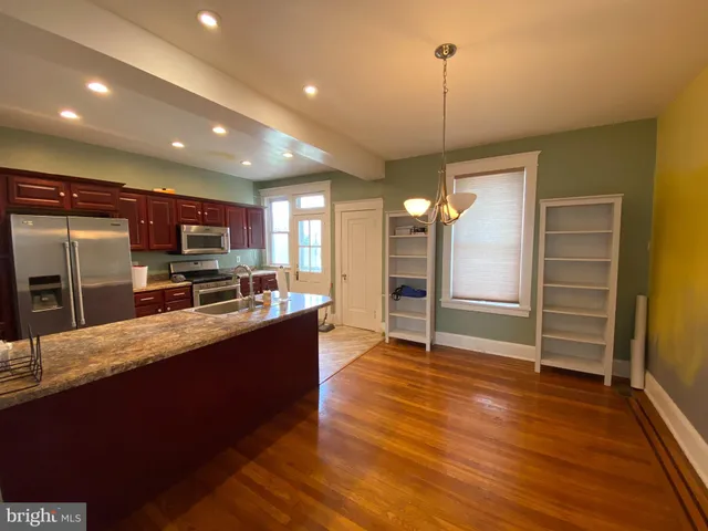 a large kitchen with kitchen island a counter space a sink appliances and cabinets