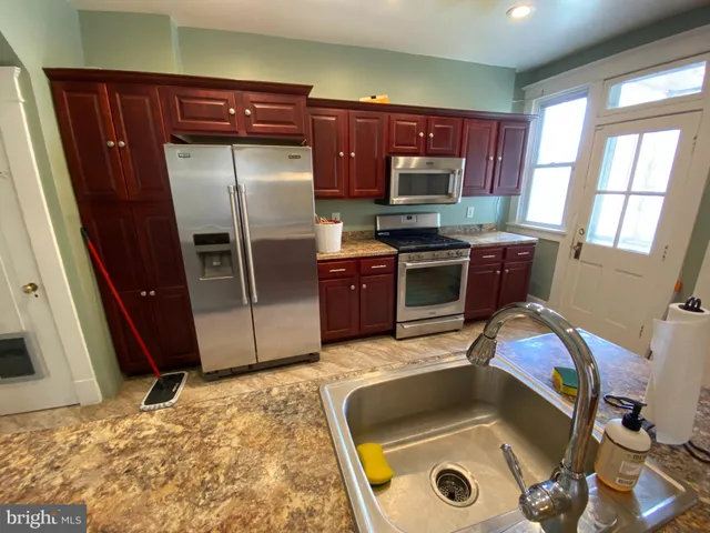 a kitchen with stainless steel appliances granite countertop a refrigerator stove and sink