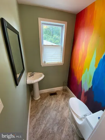 a bathroom with a sink toilet and mirror