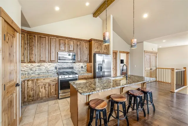a kitchen with kitchen island granite countertop wooden floors and stainless steel appliances