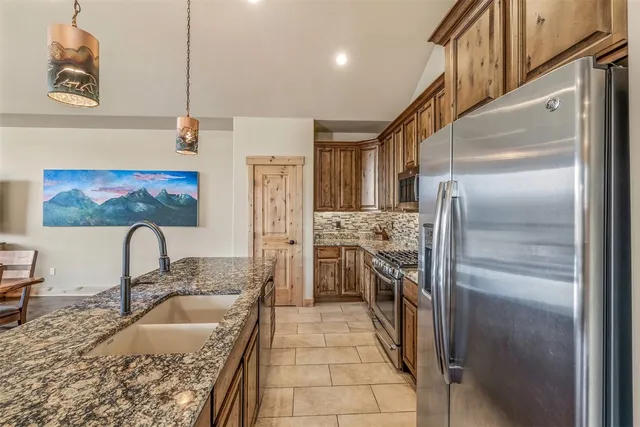 a kitchen with stainless steel appliances granite countertop a refrigerator and a sink