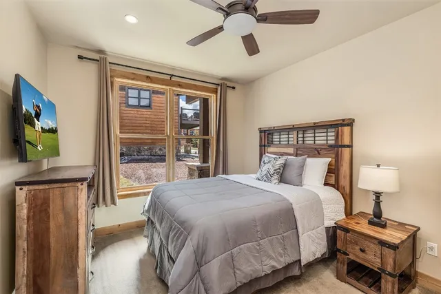 a bedroom with a bed and a flat tv screen on dresser