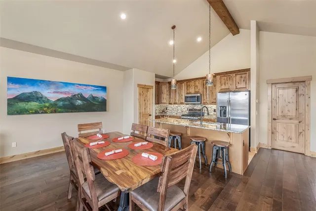 a view of a dining room with furniture a kitchen and chandelier