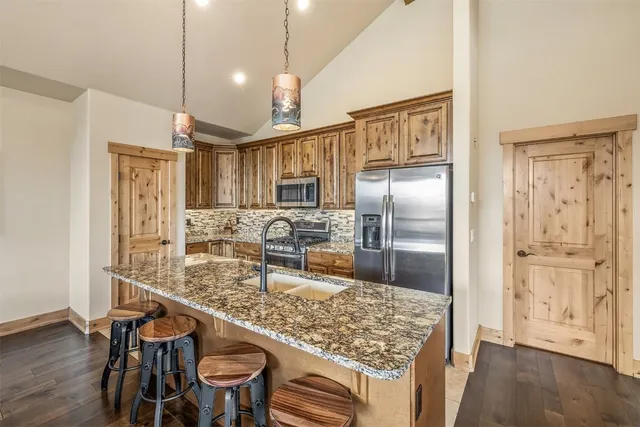 a kitchen with stainless steel appliances granite countertop a refrigerator and a stove top oven