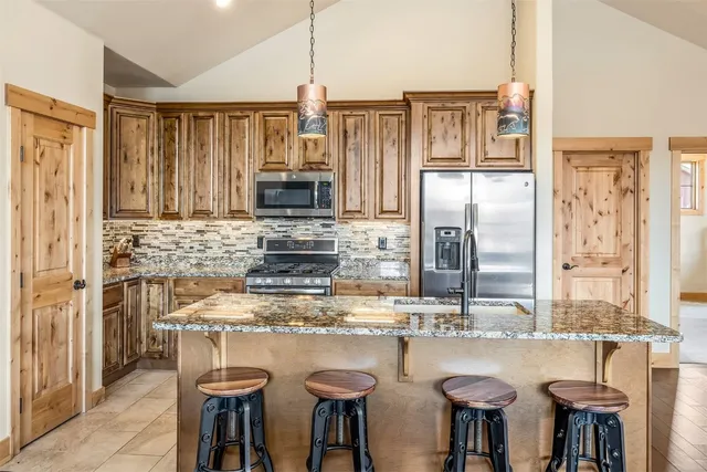 a kitchen with refrigerator and chairs