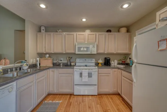 a kitchen with a sink stove cabinets and refrigerator