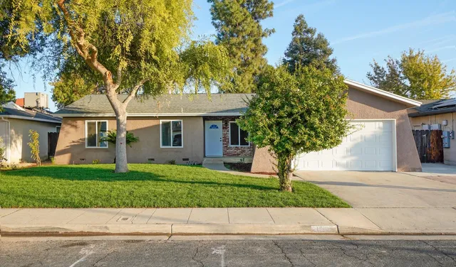 a front view of a house with a yard and a garage