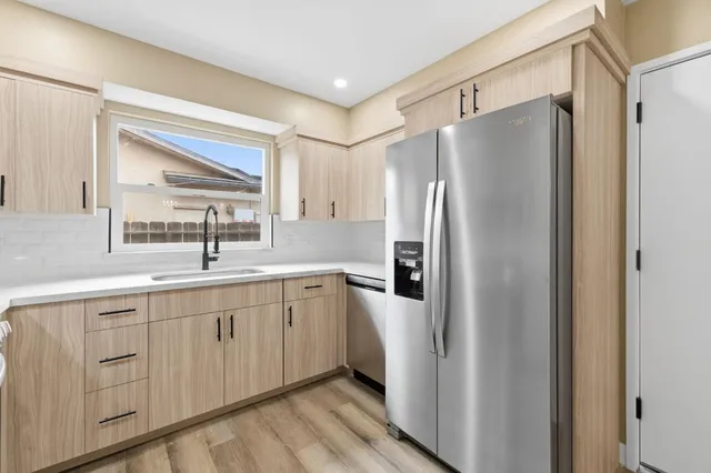 a kitchen with a refrigerator sink and cabinets