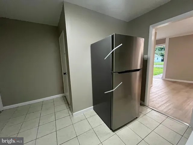 a metallic refrigerator freezer sitting in a kitchen