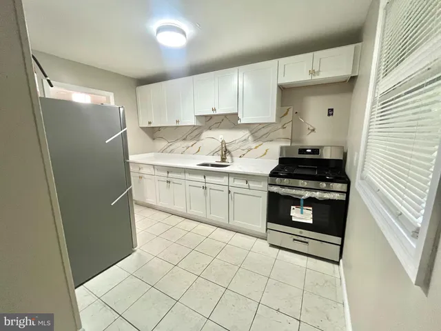 a kitchen with stainless steel appliances a refrigerator sink and cabinets