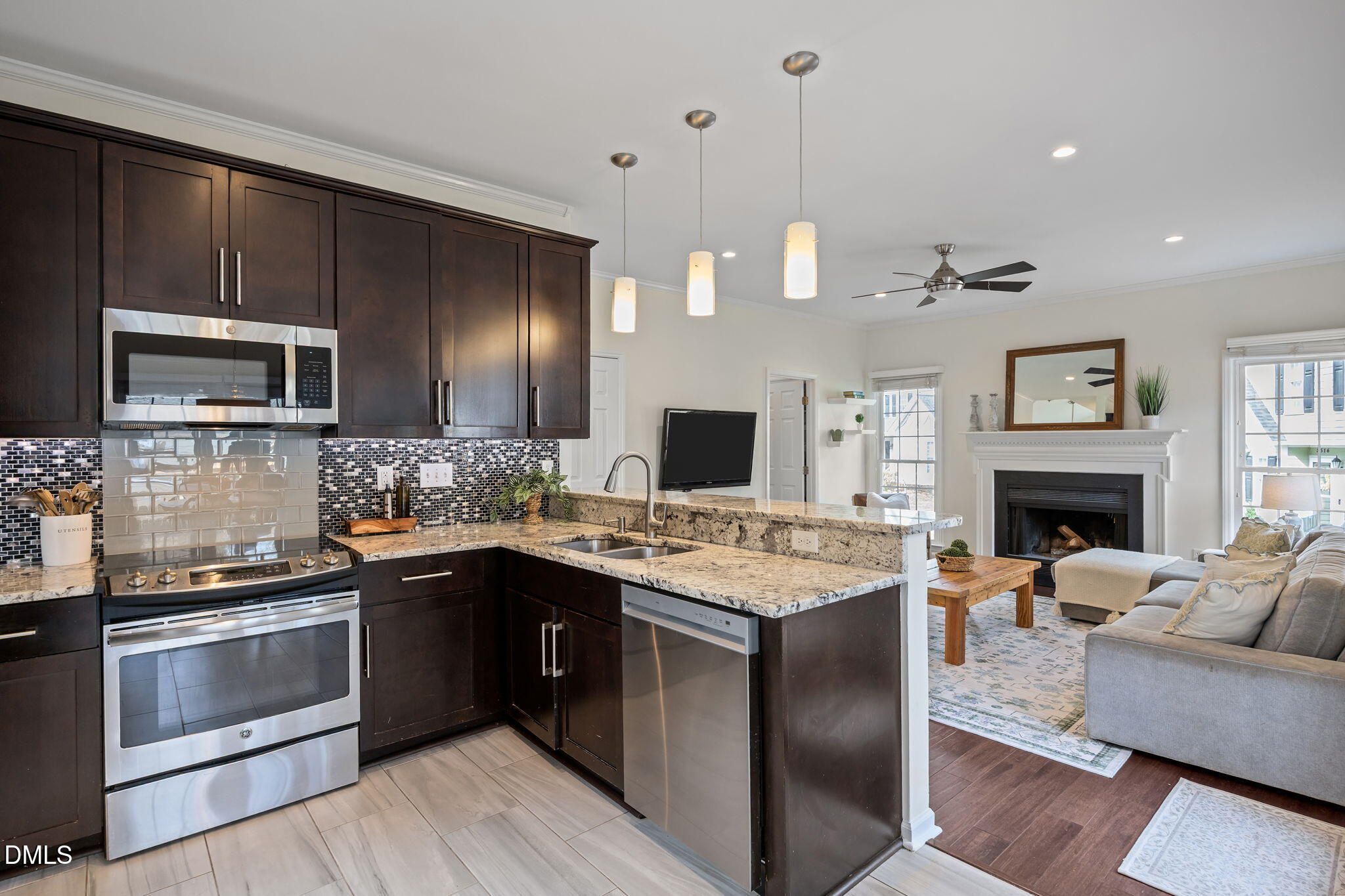 5512 Banwell Place Raleigh, NC 27613 - Photo 13 of 47 a large kitchen with stainless steel appliances granite countertop a stove a sink dishwasher a microwave oven with a dining table and chairs